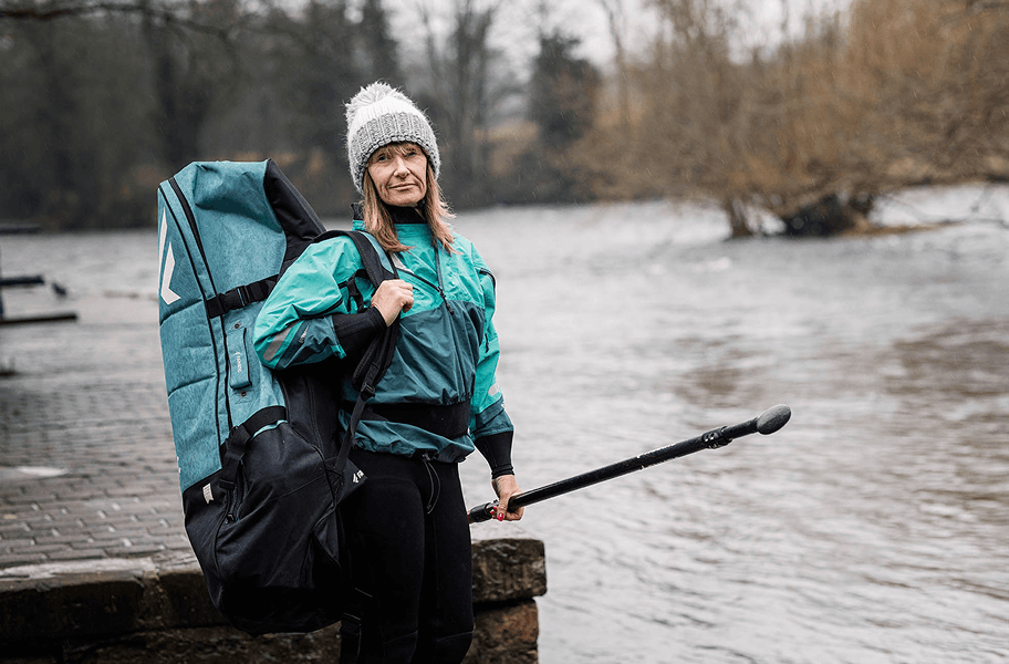 woman with sports bag by river